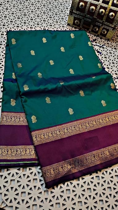 Folded teal green saree with small gold-coloured motifs and a purple border