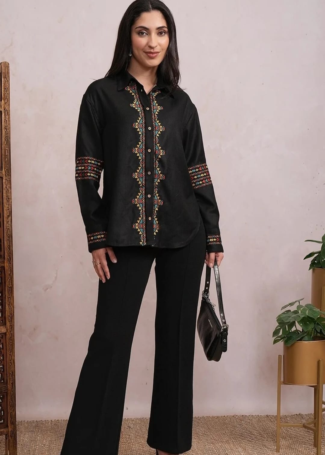 Woman wearing a black shirt with colourful embroidery