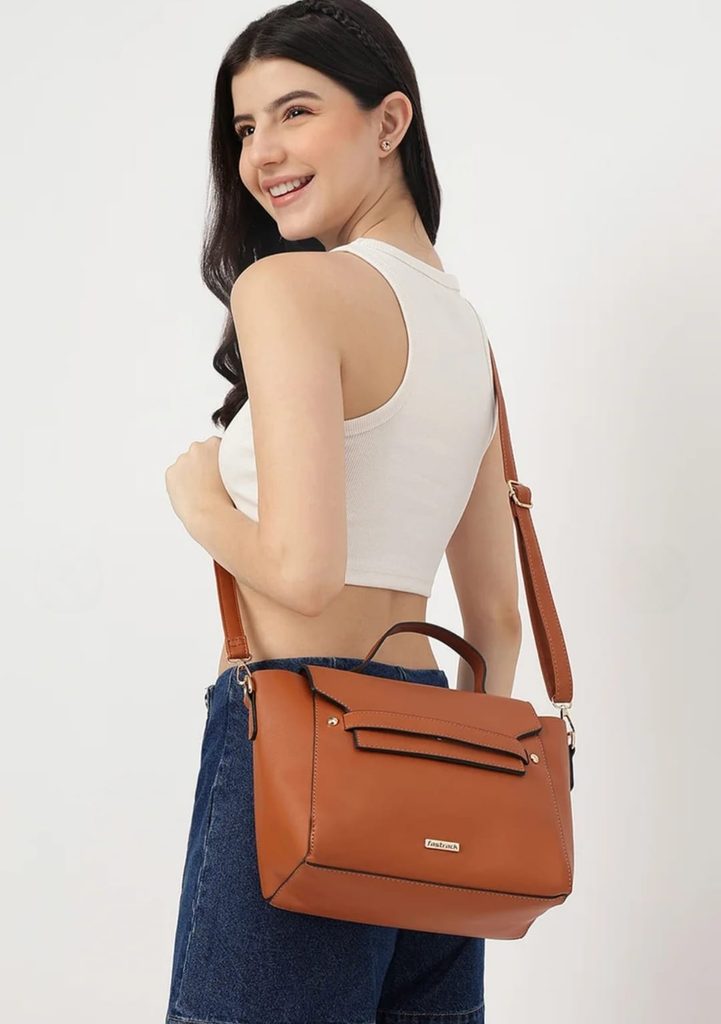 Woman wearing a Fastrack tan crossbody handbag with a flap design and adjustable shoulder strap
