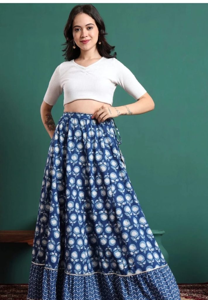 Woman wearing a CHARMANT blue printed maxi skirt with a white crop top