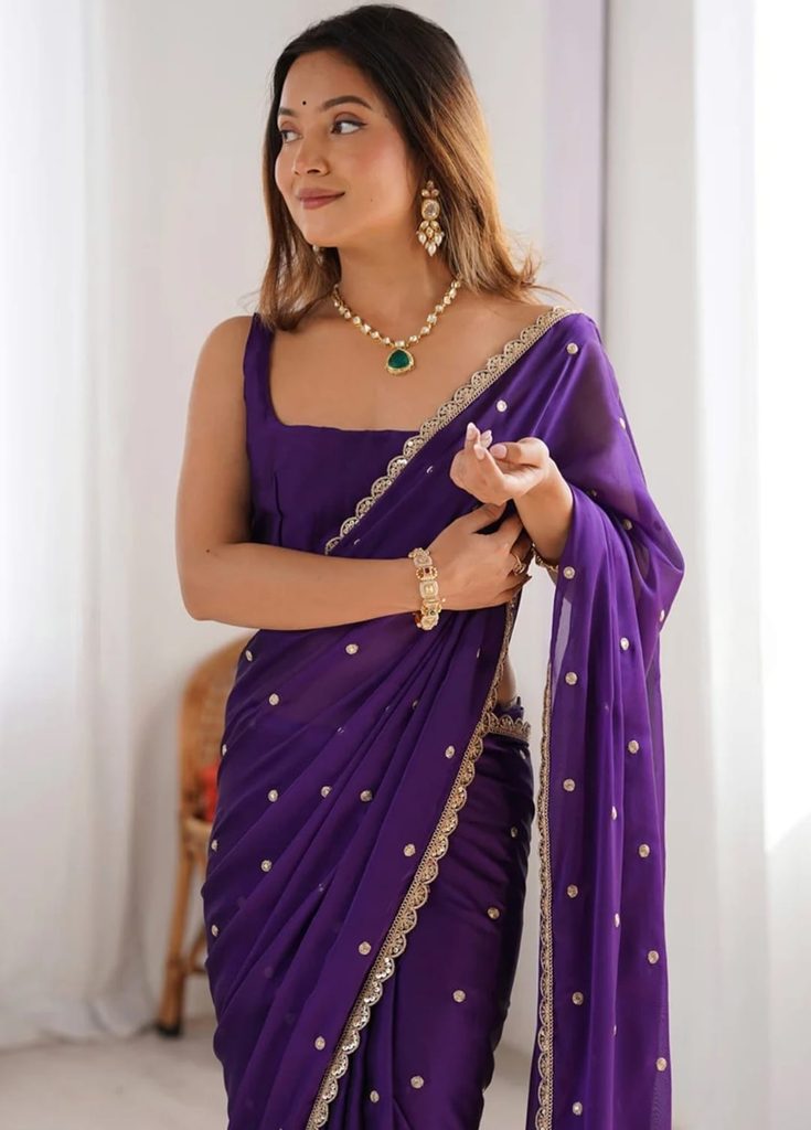 Close-up of purple saree with gold-tone embellishments and scalloped border