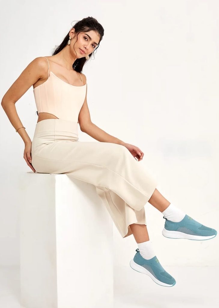 Model styling Campus teal green slip-on sneakers with a cream outfit