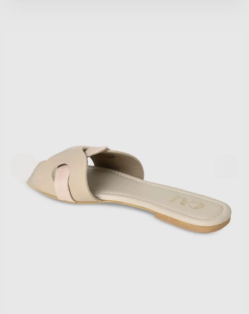 Side profile of CAI beige flats showing the low heel and open back